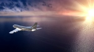 stock-footage-flying-airplane-with-sunset-over-blue-ocean